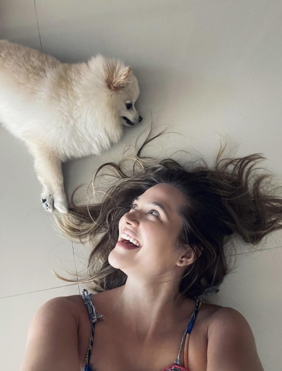 Na foto, a atriz Juliana Paiva deitada ao lado do seu cachorro Sancho da raça lulu-da-pomerânia — Foto: ( Instagram/ @juulianapaiva/ Reprodução)
