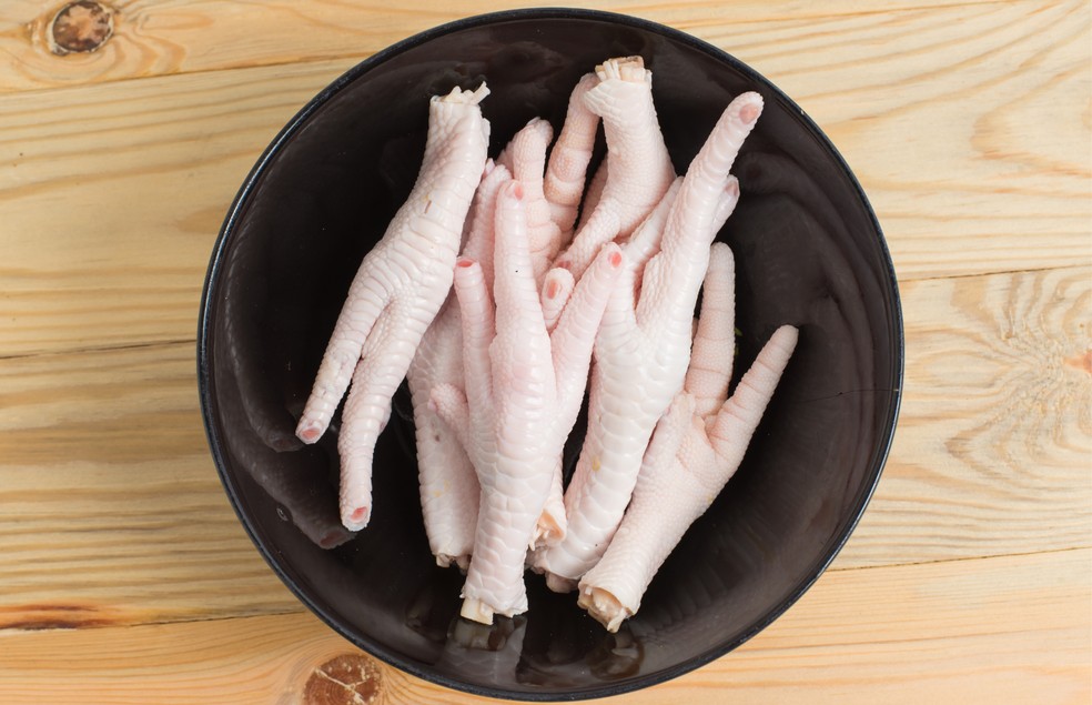 Especialistas não recomendam a oferta de pé de galinha cru para cães, pois pode trazer riscos à saúde — Foto: Canva/ Creative Commons